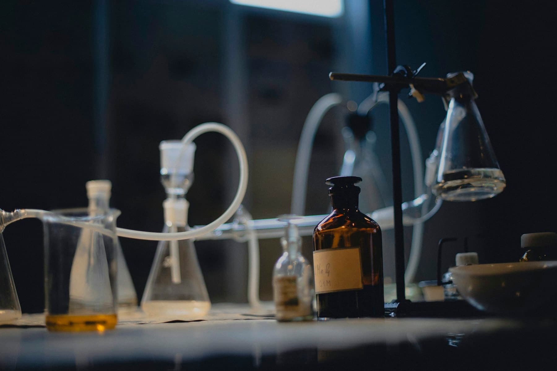 Laboratory glassware and a reagent bottle on a bench